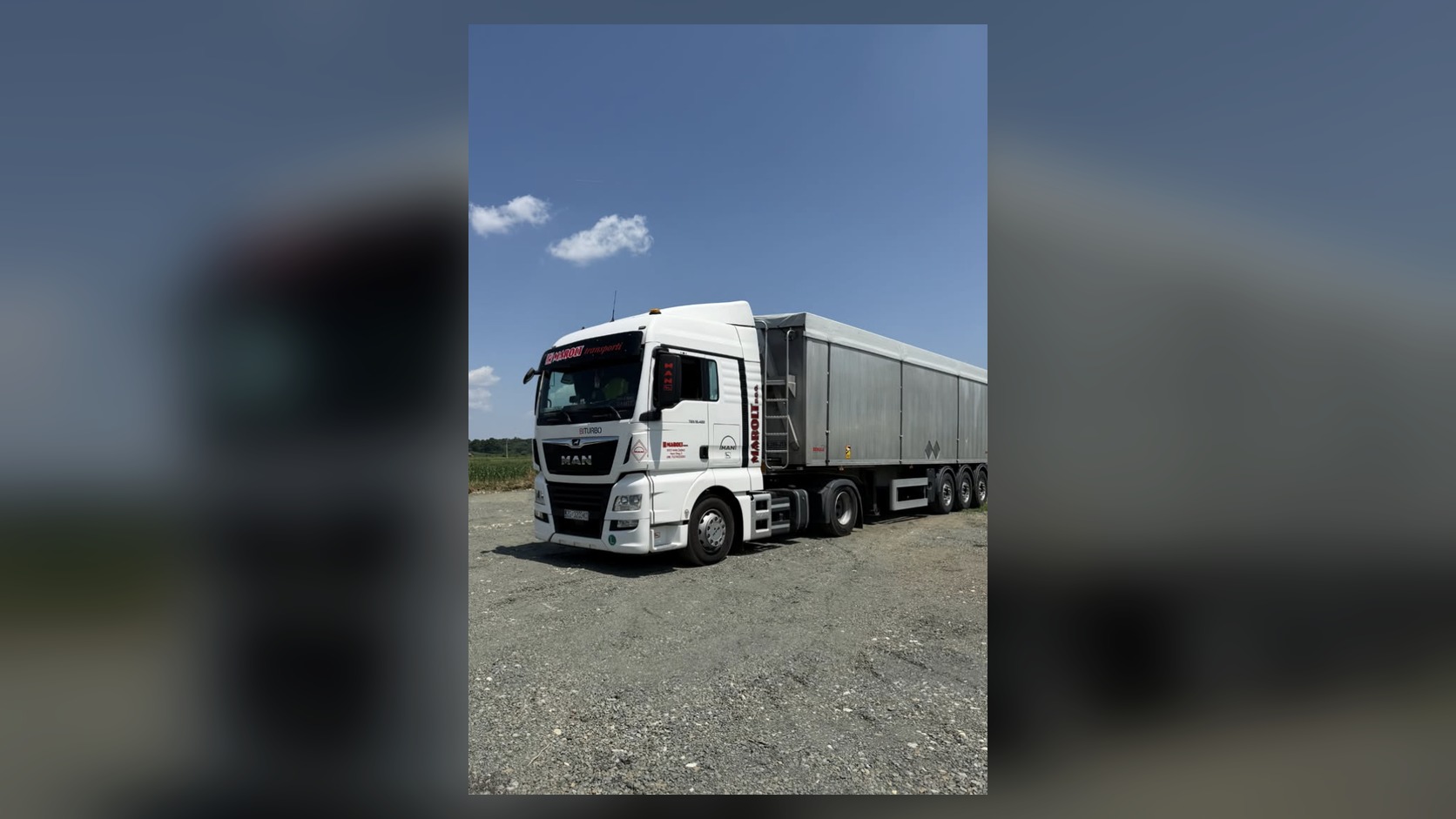 Bijeli MAN s prikolicom s pokretnim podom